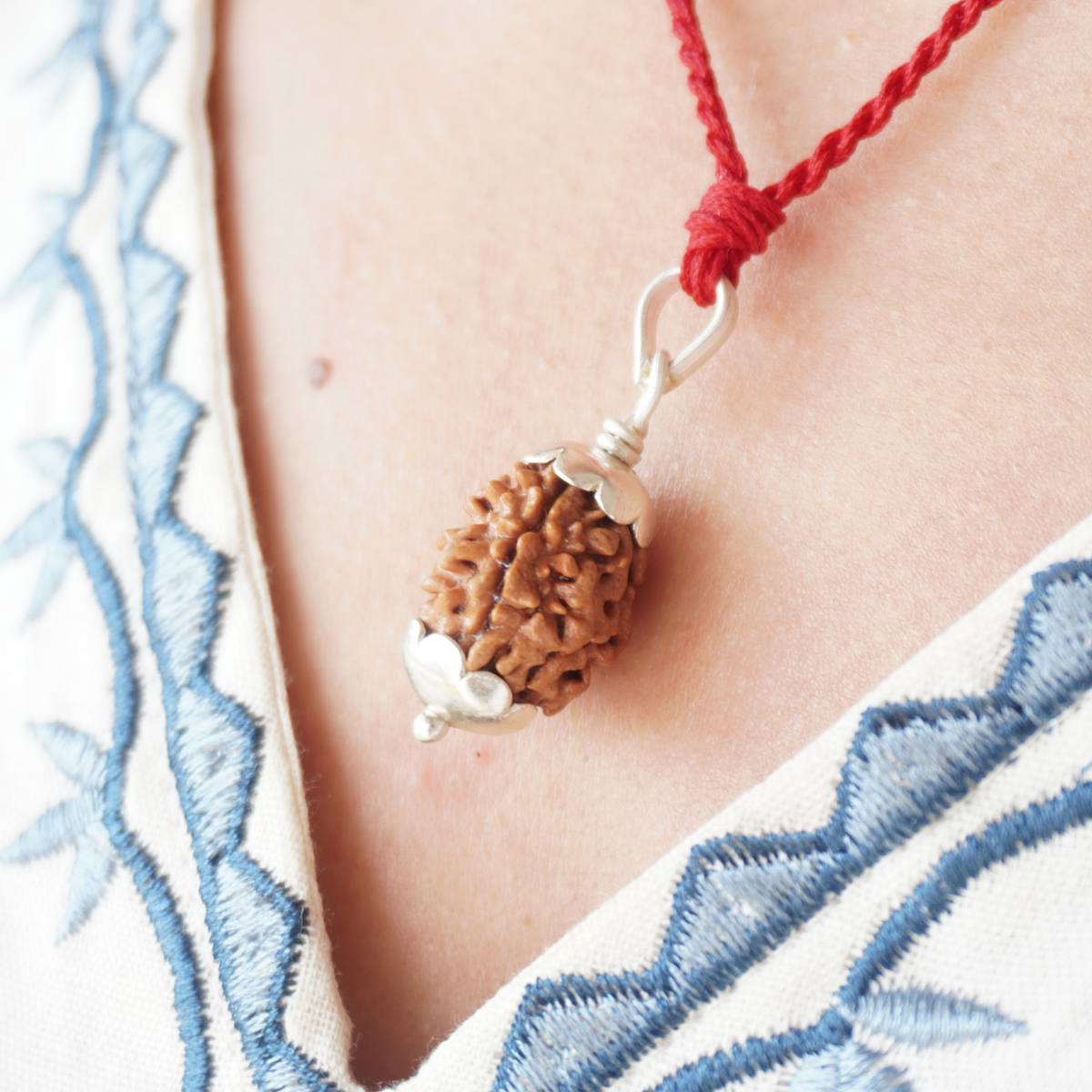 Red Thread 2 Mukhi Rudraksha pendant worn, close up