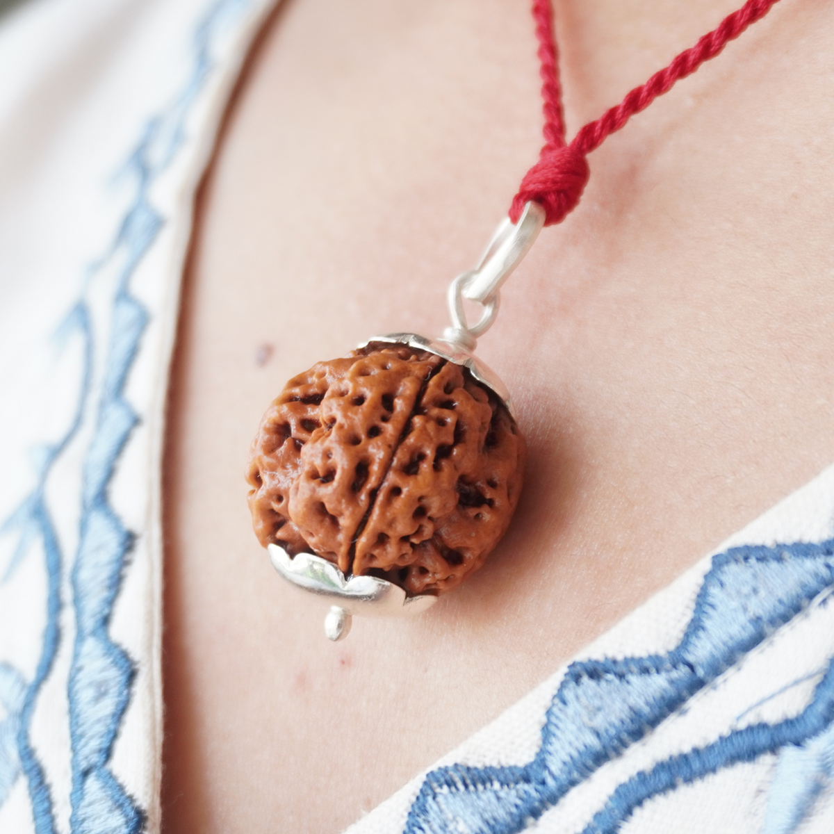 Red Thread 4 Mukhi Rudraksha pendant worn, close up