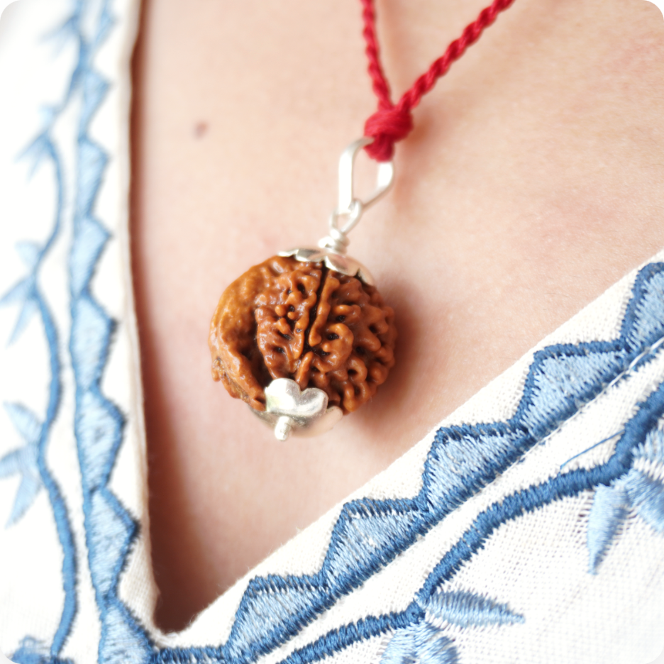 Red Thread Ganesh Mukhi Rudraksha pendant worn by a woman, close up