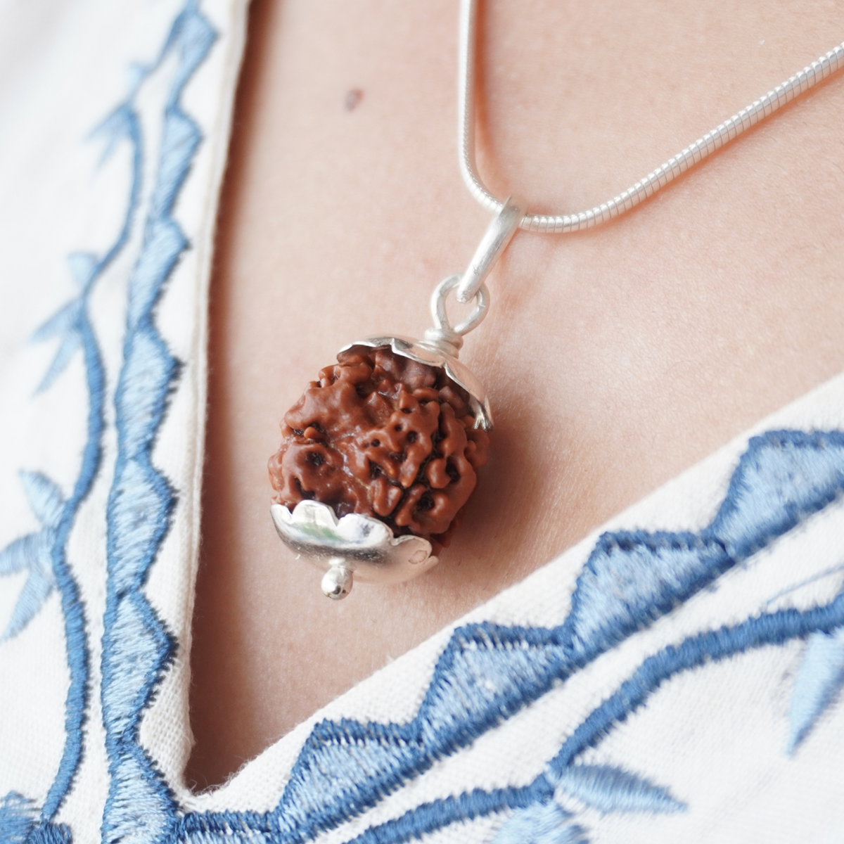 Silver Chain 3 Mukhi Rudraksha pendant worn, close up